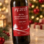 Detail červené firemní etikety PF 2027 na lahvi vína, s bílými stromečky a místem pro vlastní logo.
