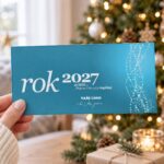 Novoročenka Abstraktní řetězce s přáním úspěšného roku 2027 držená v ruce.